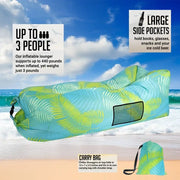Inflatable lounge chair with palm leaf pattern on a beach, featuring text about capacity and features.